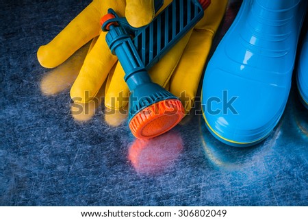 Composition of rubber boots leather safety gloves and water sprayer.