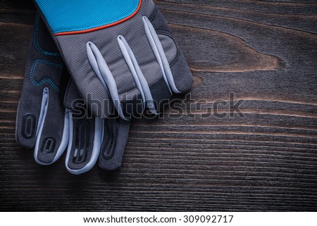 Working gardening gloves on vintage wooden board agriculture concept.