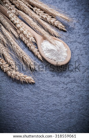 Wooden spoon with flour bunch of wheat ears.