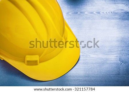 Yellow building helmet on wooden board construction concept.