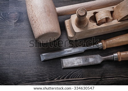 Wooden mallet flat chisels planer on wood board.