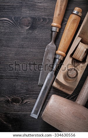 Set of wooden mallet metal chisels planer on wood board.