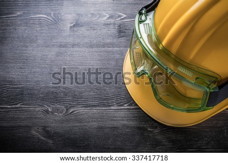 Safety glasses building helmet on wooden board construction concept.