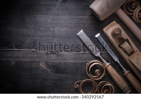 Chisels shaving plane lump hammer planning chips on wooden board.