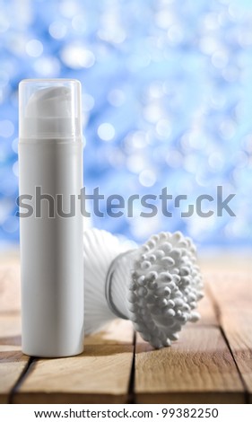 cosmetic spray and cotton swabs on wooden table