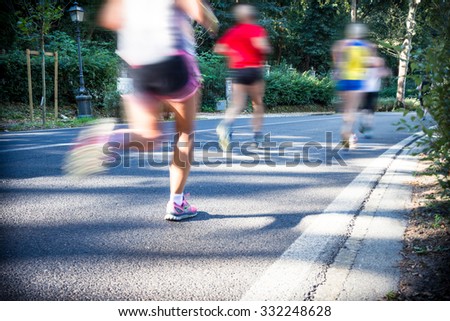 City marathon runners. Long exposure with motion blurred effect. Selective focus on the foreground. Slight vignetting effect.