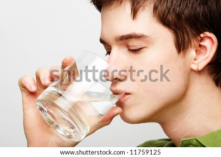 young handsome man is drinking mineral water
