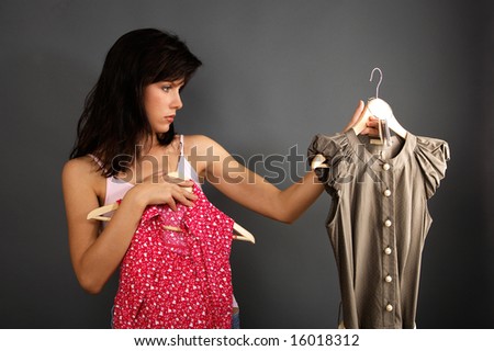 woman is deciding which dress to buy