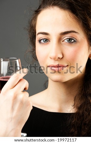 young pretty caucasian woman with wine over grey