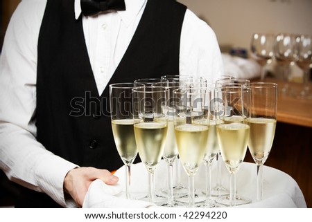 professional waiter in uniform is serving wine