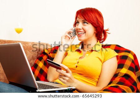 cute caucasian woman is holding the credit card and speaking on the phone