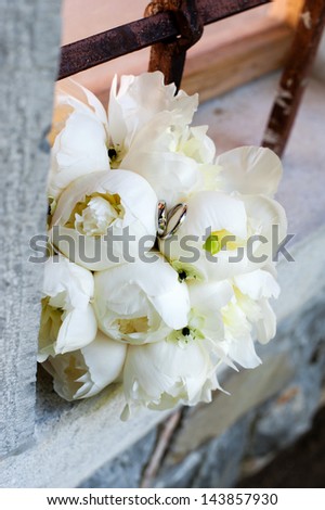 Wedding rings on white roses wedding bouquet