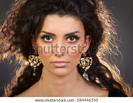 Portrait of a beautiful young woman with her earrings