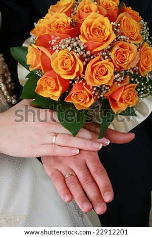 Hands of a married couple holding bouquet