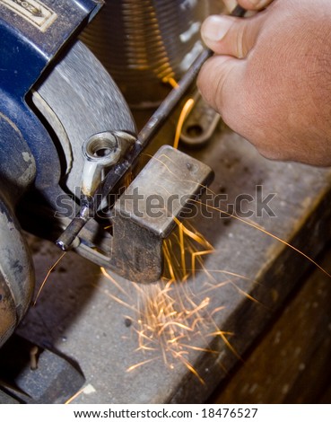 grinding metal rod with sparks flying