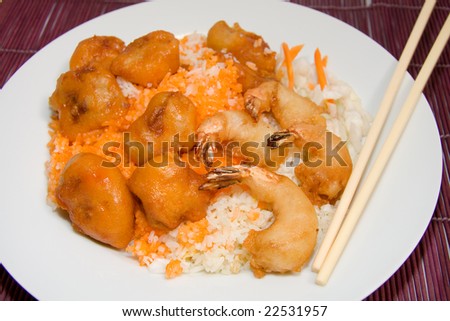 plate of sweet and sour pork and shrimp on fried rice on purple bamboo place mat