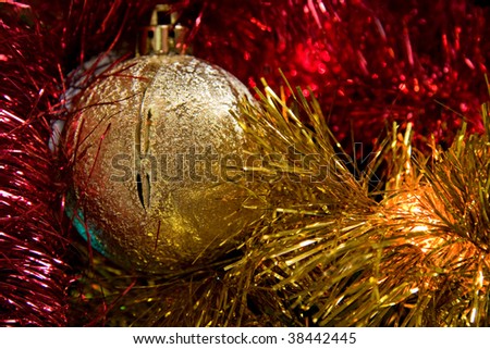 gold christmas ball among red and gold tinsel