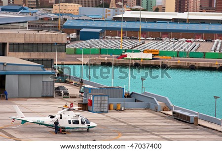 harbor with cars waiting to be uploaded for export, harbor pilot helicopter in foreground