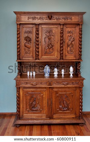 old fashioned wood sideboard with intricate wood carving of animals and nature with blue and white porcelain ornaments