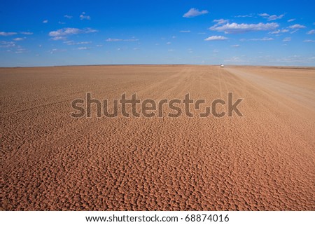 Verneukpan, South Africa, large flat desert pan where land speed records are attempted with car disappearing in the distance