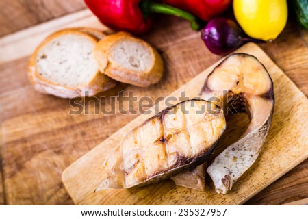 smoked fish with garnish on wooden plate