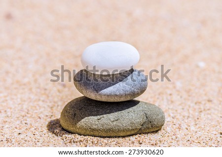 different stones in the brown sand on the beach