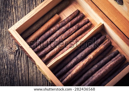 humidor with quality cigar on an old wooden table