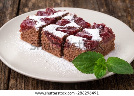 sliced piece of plum cake with cocoa sprinkled with sugar