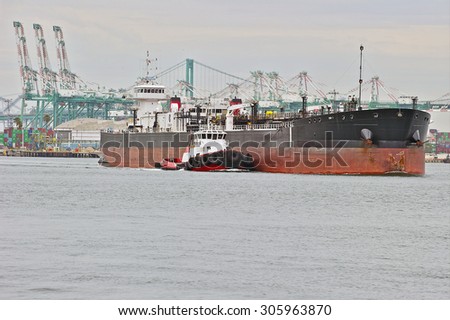 LOS ANGELES/CALIFORNIA - USA: AUGUST 6, 2015:  A heavy-lift marine vessel is escorted by a tug boat out of the harbor. The largest port in the U.S. Port of Los Angeles in San Pedro, California USA