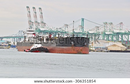 LOS ANGELES/CALIFORNIA - USA: AUGUST 6, 2015: A heavy-lift marine vessel is escorted by a tug boat out of the harbor. The largest port in the U.S. Port of Los Angeles in San Pedro, California USA