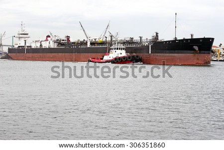 LOS ANGELES/CALIFORNIA - USA: AUGUST 6, 2015: A heavy-lift marine vessel is escorted by a tug boat out of the harbor. The largest port in the U.S. Port of Los Angeles in San Pedro, California USA