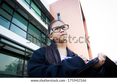 Cute little Asian child pretending to be a business woman looking up