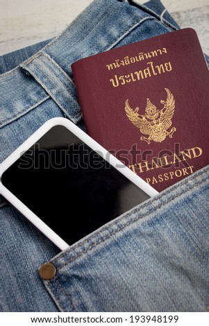 Thai passport in pocket of a jeans with smart phone
