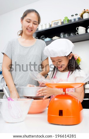 Adorable Asian family baking together in the kitchen