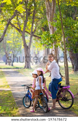 Bike riding - Asian child with mother on bike, active family concept
