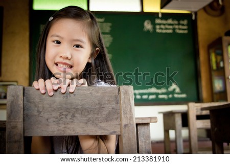 Happy Asian child in the old vintage classroom