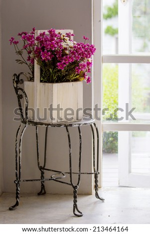 Vintage flowers in wooden box on the chair