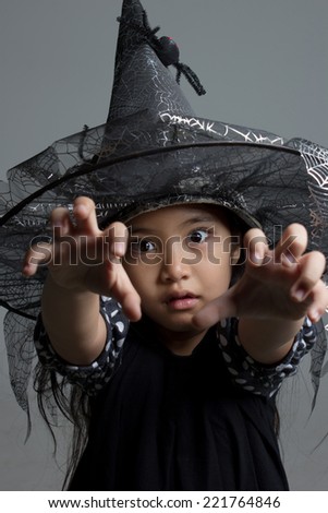 Portrait of little Asian girl in black hat and black clothing
