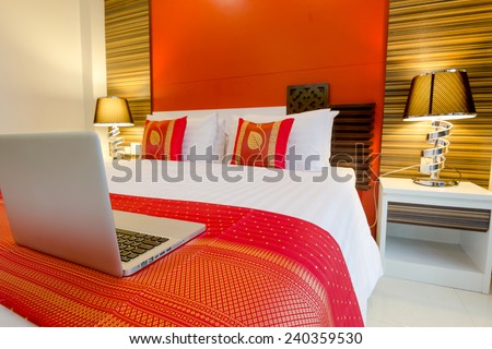 Labtop on the bed, oriental style apartment Service Room at Patong Beach Phuket, Thailand