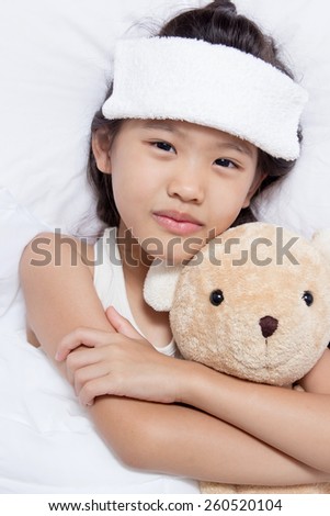 Little Asian child has fever and laying on the bed, get well