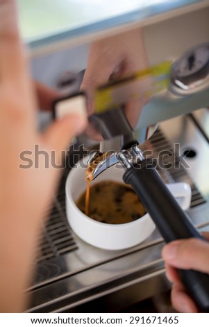 Close up of coffee maker pouring hot coffee from the espresso machine