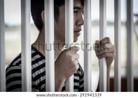 The Asian prisoner standing behind the jail