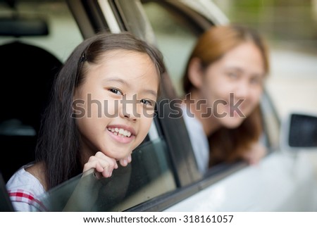 Happy Asian family sitting in the car