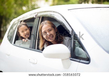 Happy Asian family sitting in the car