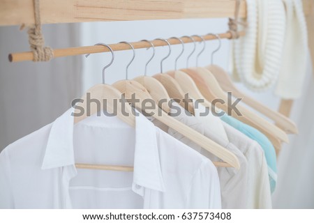 White shirts hanging on white built-in cloths racks