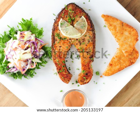 Fried steak from a salmon with a sauce and lemon, ready to the serve