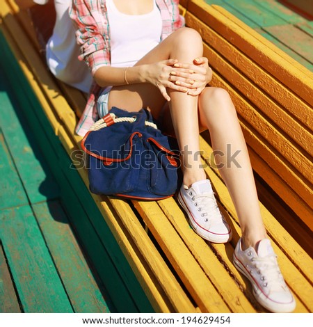 Trendy hipster resting in the city, beautiful slender female legs in summer