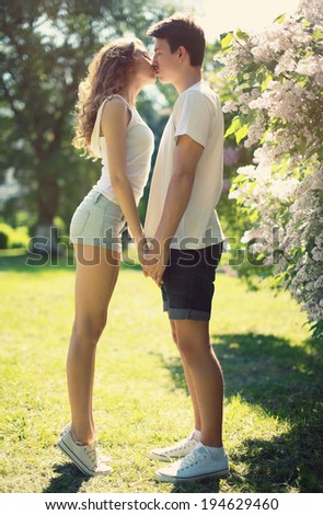 Young couple in love, sensual kiss in sunny summer day
