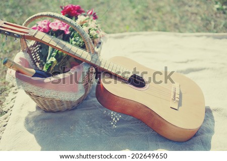 Guitar, basket with wine and bouquet of flowers. Vintage tender background. Romance, love, date, Valentine\'s day - concept