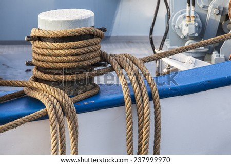 detail of the ropes with which a boat is docked in the harbor, photographed on a sunny day in winter